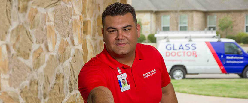 Glass Doctor of Muskoka, ON Glass Doctor service professional at the door with the Glass Doctor van parked out front.